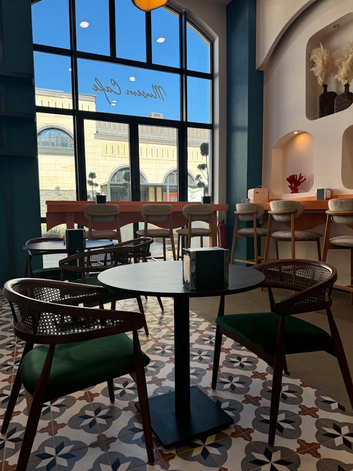 A stylish, modern cafe interior with elegant chairs and large windows, creating a cozy atmosphere.